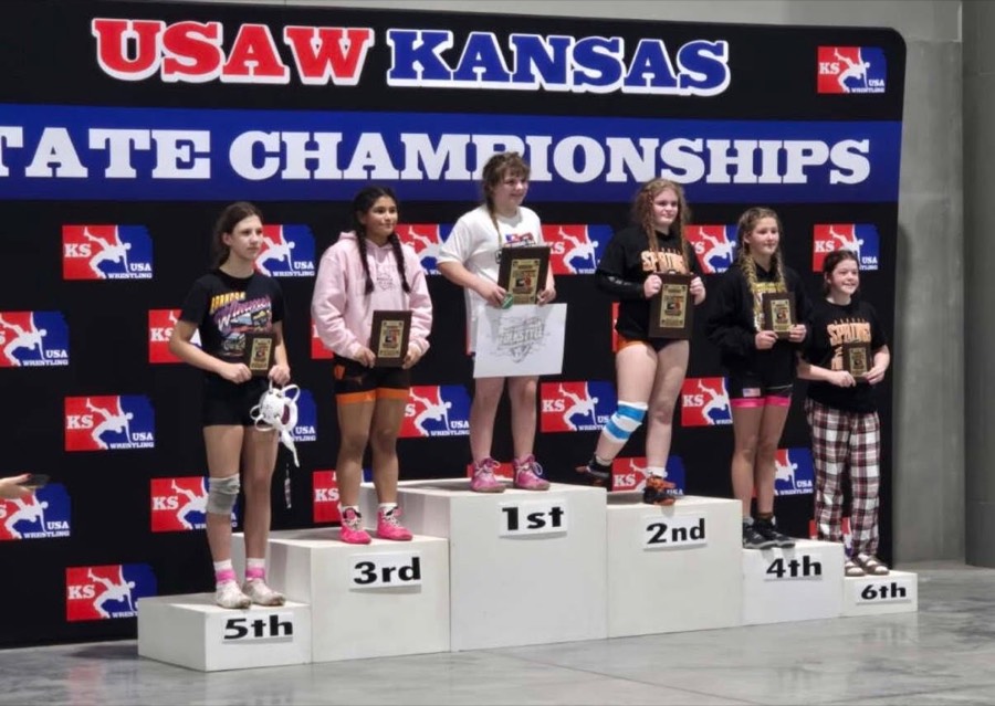 Girls wrestlers standing on the state championship podium