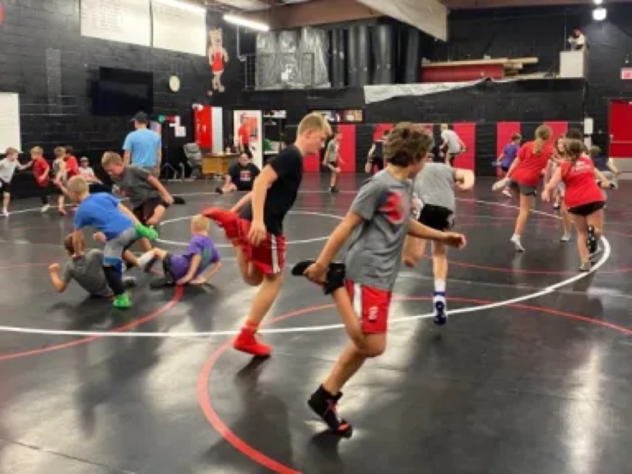 Young wrestlers running drills on the practice mat