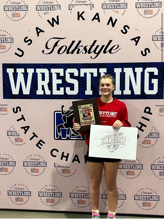 Ellsworth wrestler holding a state championship plaque and bracket