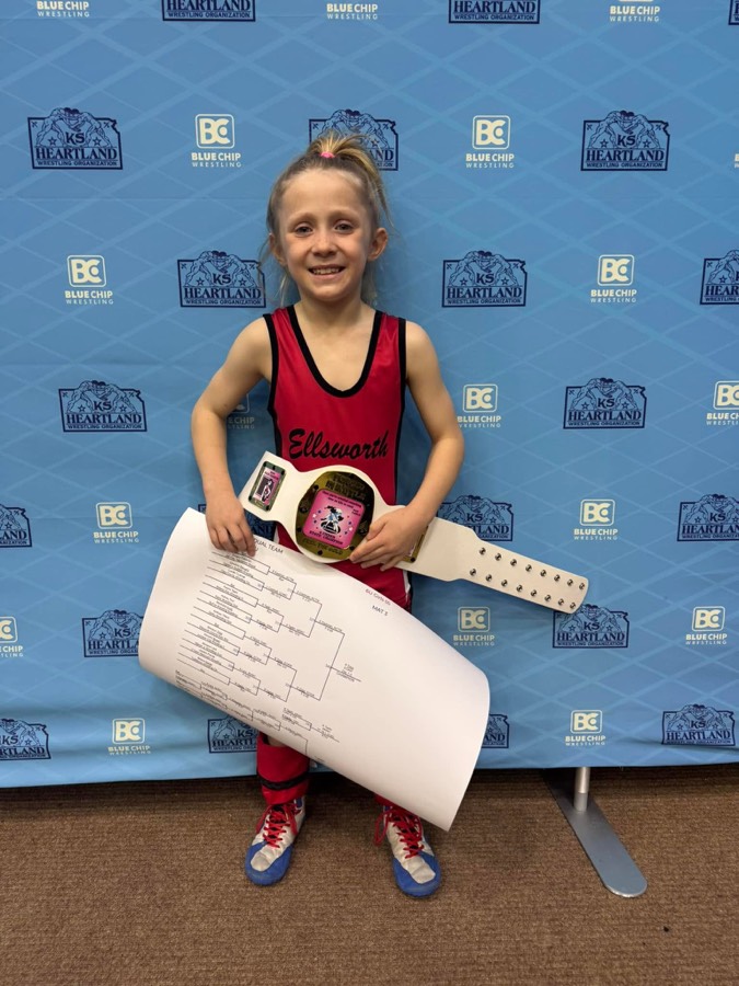 Young ECKWC wrestler holding a championship belt and tournament bracket
